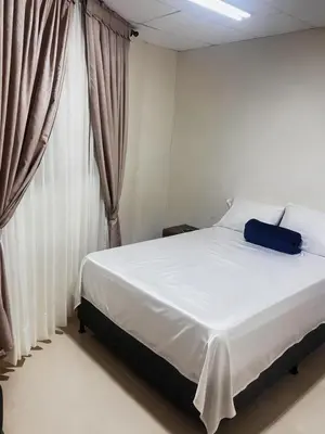 a bed with a blue bag sitting on top of it at Hotel Plaza de Toros in Manizales
