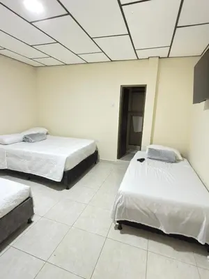 a room with two beds and a tv on the ceiling at Hotel Plaza de Toros in Manizales