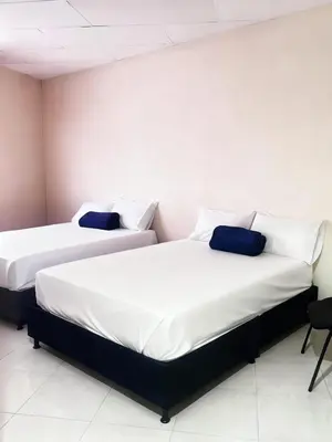 two beds sitting next to each other in a room at Hotel Plaza de Toros in Manizales