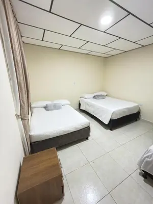 a room with two beds and a table in it at Hotel Plaza de Toros in Manizales