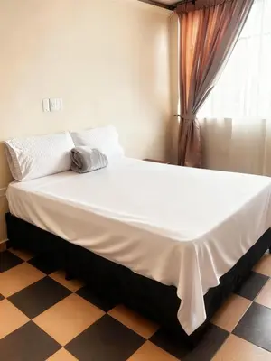 a large bed in a room with a checkered floor at Hotel Plaza de Toros in Manizales