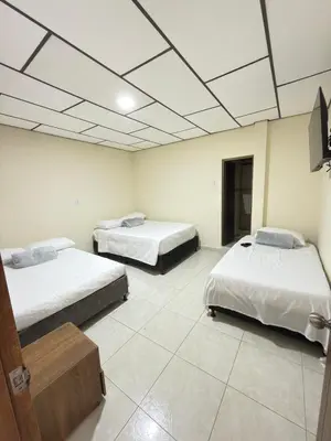 a room with two beds and a tv on the ceiling at Hotel Plaza de Toros in Manizales
