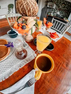 a table with a cup of coffee and glasses of orange juice at Almaia 17 in Rionegro