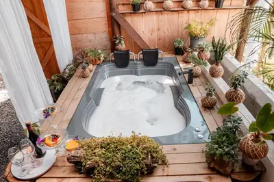 a hot tub on a deck with potted plants at Almaia 17 in Rionegro