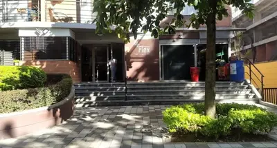 a building with stairs and a tree in front of it at Apartment near Atanasio Girardot Stadium in Medellín