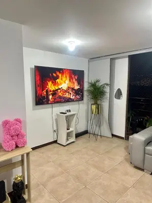 a living room with a fire on the wall at Apartment near Atanasio Girardot Stadium in Medellín