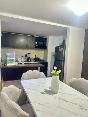 a kitchen with a table with a vase of flowers on it at Apartment near Atanasio Girardot Stadium in Medellín