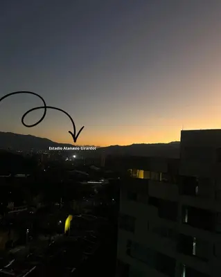 a bird flying in the sky over a city at Apartamento cerca del estadio de Medellín in Medellín