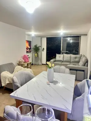a living room with a white table and a couch at Apartamento cerca del estadio de Medellín in Medellín