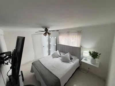 a bedroom with a bed with a ceiling fan at Happy home in Guayaquil