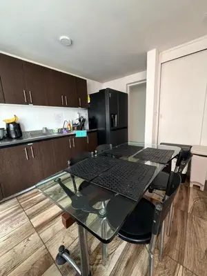 a kitchen with a glass table and some chairs at Happy home in Guayaquil