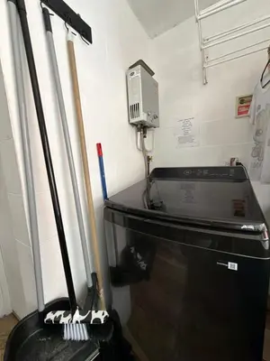 a room with a stove and a washing machine at Happy home in Guayaquil