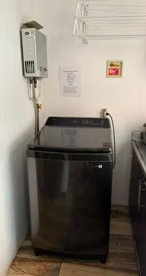 a microwave sitting on top of a stove in a kitchen at Happy home in Guayaquil