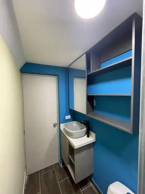 a bathroom with blue walls and a toilet and a sink at Smart apartment in Bello