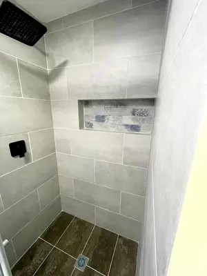 a bathroom with a shower with gray tiles at Smart apartment in Bello