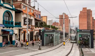 a train on the tracks in a city with buildings at Exclusivo Loft de Lujo en Medellín in Medellín