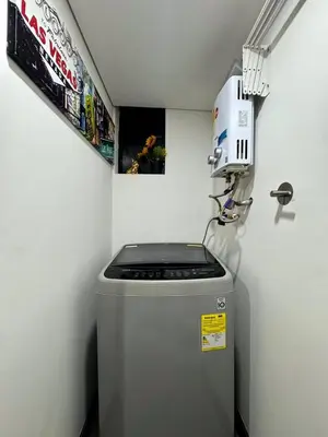 a small refrigerator in a room with a machine at Exclusivo Loft de Lujo en Medellín in Medellín