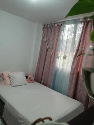 a small bedroom with a bed and a window at Abis in Medellín