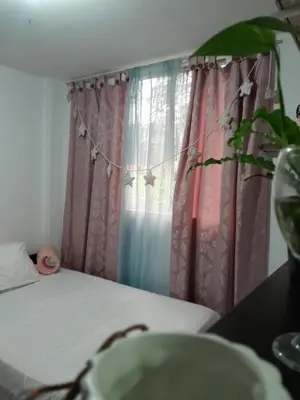 a bedroom with a bed with pink and blue curtains at Abis in Medellín