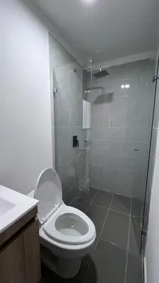 a bathroom with a toilet and a glass shower at Acogedor y cómodo loft Medellín cerca al Estadio in Medellín
