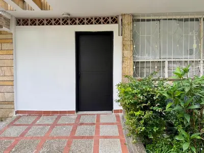 a black door on the side of a house at Acogedor y cómodo loft Medellín cerca al Estadio in Medellín