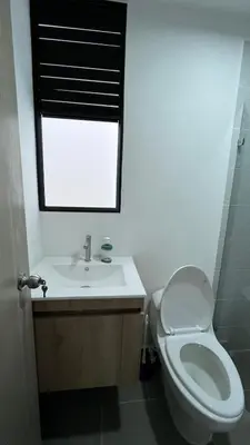 a bathroom with a toilet and a sink and a window at Acogedor y cómodo loft Medellín cerca al Estadio in Medellín