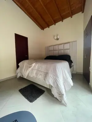 a bedroom with a bed with a white comforter at Apartahabitacion Laureles in Medellín