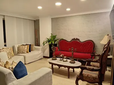a living room with a red couch and a table at Apartahabitacion Laureles in Medellín
