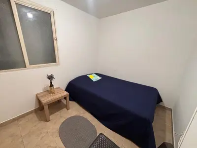 a small bedroom with a blue bed and a table at Casa Minca in Medellín