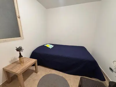 a small bedroom with a bed and a table at Casa Minca in Medellín