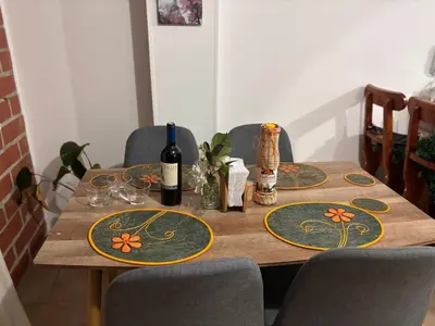a wooden table with chairs and a bottle of wine at Casa Minca in Medellín
