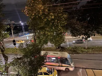 a bus driving down a city street at night at Casa Minca in Medellín