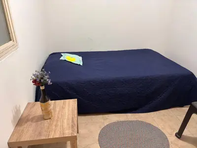 a bedroom with a bed with a vase of flowers on a table at Casa Minca in Medellín