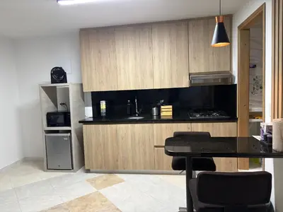 a kitchen with a black counter top and wooden cabinets at Laureles70 in Medellín