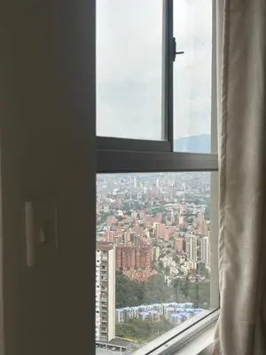 a view of a city from an open window at Elena house in Medellín