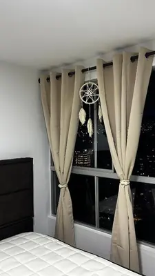 a bedroom with curtains in front of a window at Elena house in Medellín
