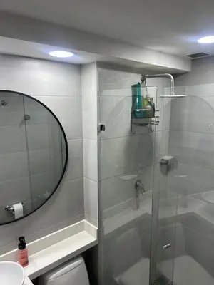 a bathroom with a shower with a mirror and a toilet at Elena house in Medellín