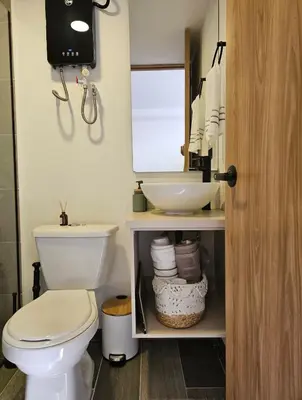 a bathroom with a white toilet and a sink at Inner Bloom in Medellín
