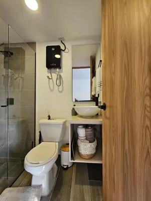 a bathroom with a toilet and a sink and a shower at Inner Bloom in Medellín