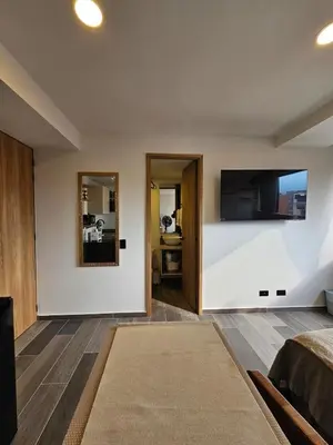 a room with a bed and a tv on a wall at Inner Bloom in Medellín