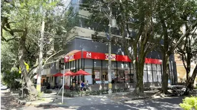 a building with a restaurant with red umbrellas and trees at Inner Bloom in Medellín