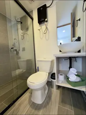 a bathroom with a toilet and a sink and a shower at Inner Bloom in Medellín