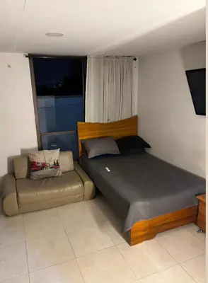 a bed and a couch in a bedroom at Aparta estudio hasta para 4 personas Max in Medellín
