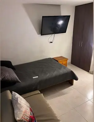 a bedroom with a bed and a flat screen tv at Aparta estudio hasta para 4 personas Max in Medellín