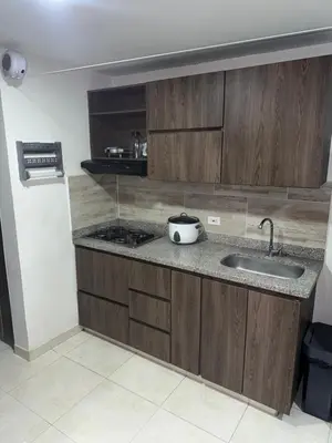 a kitchen with wooden cabinets and a sink at Aparta estudio hasta para 4 personas Max in Medellín