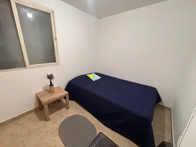 a small bedroom with a blue bed and a table at Minca in Medellín