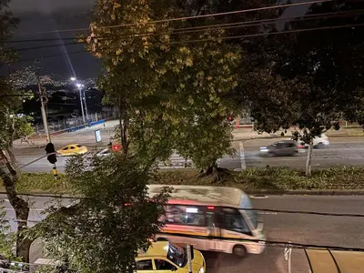 a bus driving down a city street at night at Minca in Medellín