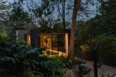 a tiny house in the woods at night at Selvva suites cabaña de lujo romántica con jacuzzi in Rionegro