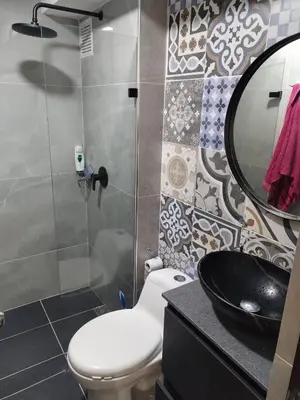 a bathroom with a toilet and a sink and a mirror at Apt en sabaneta in Sabaneta