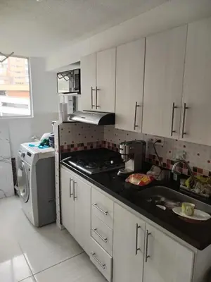 a kitchen with white cabinets and a sink and a stove at Apt en sabaneta in Sabaneta